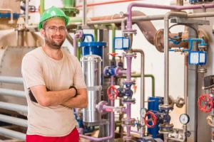 industry-worker-posing-inside-factory-with-bars-pipes-around