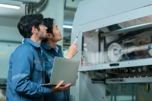 Two engineers inspecting a machine