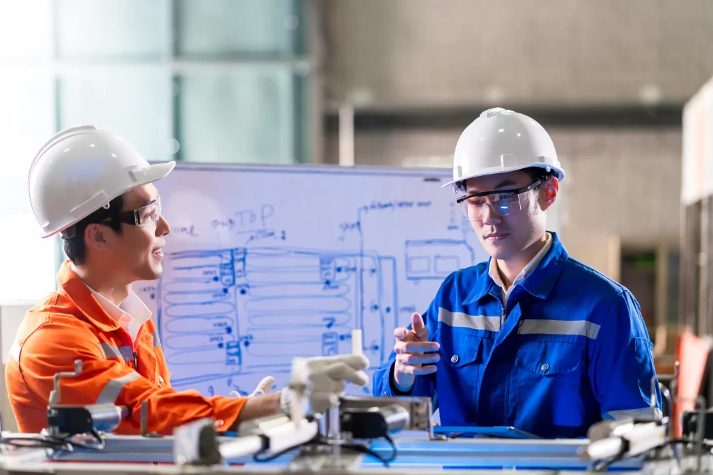 Engineers having a discussion about a mechanical part in a factory