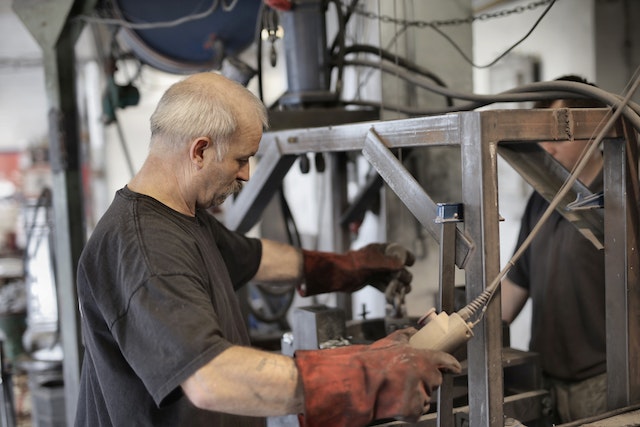 Experienced handyman with white hair working on a machine